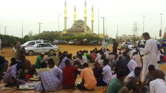 Pejalan kaki dan masyarakat setempat melakukan buka puasa bersama di Khartoum, Sudan. Iftar on the road di Sudan cukup berbeda dengan Indonesia. Kalau di Sudan, mereka sampai memaksa bahkan sebagian orang menyebutnya begal Ramadan.